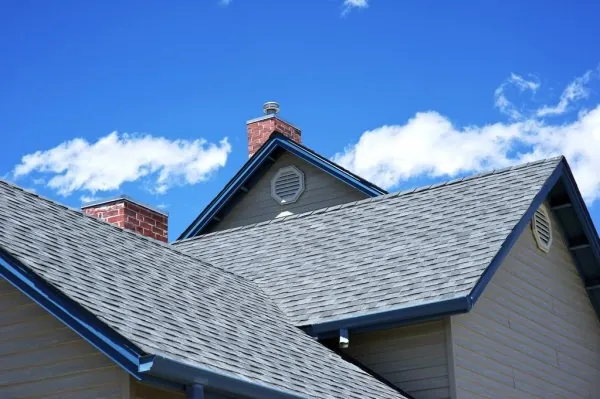 Finished asphalt shingle roof with blue trim on a Ponca City home